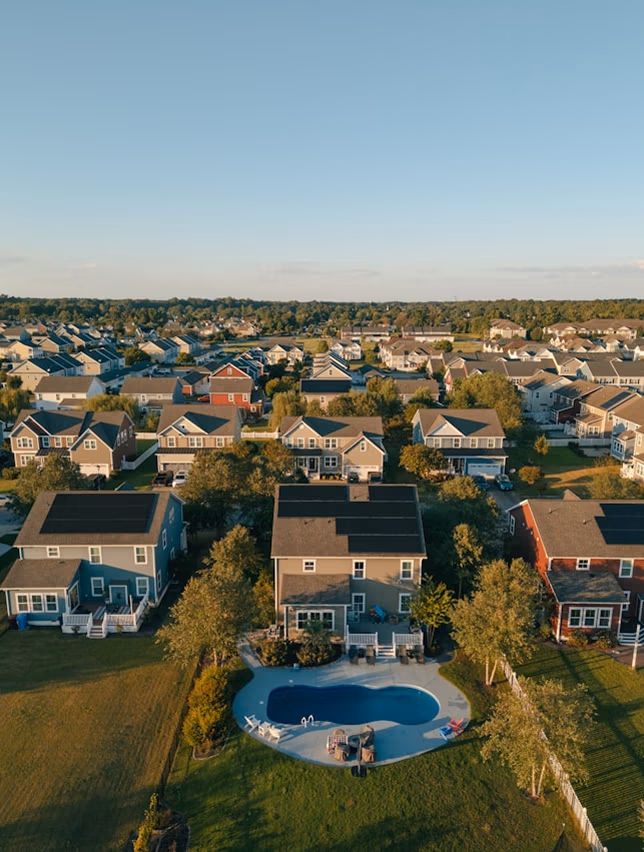 Aerial view of a neighborhood with solar panels on house roofs.